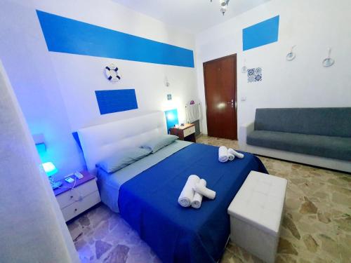 a bedroom with a blue bed and a couch at Anthony House in Villafranca Tirrena