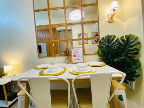 a white table with yellow dishes on it in a room at S Residences Condo PoolView Balcony in SM MOA near NAIA in Manila