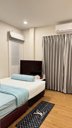 a bedroom with two beds and a window with curtains at Vela Nakhon Si Thammarat in Nakhon Si Thammarat