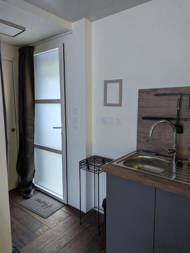 une cuisine avec un évier et un réfrigérateur dans l'établissement Au coeur des rias, studio Bélon, proche de la mer, à Moëlan-sur-Mer