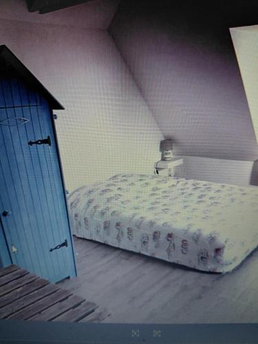 a bedroom with a bed and a blue door at Donemat in Arzon