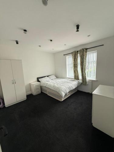 a white bedroom with a bed and two windows at 3 Bed Semi, Bingley, BD16, Free Parking, Wi-Fi in Bingley