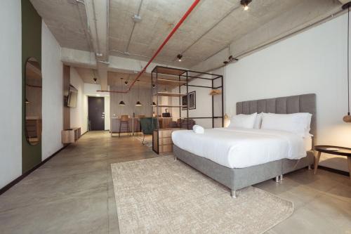 a bedroom with a large bed and a living room at Enchanted Elegance in Laureles in Medellín