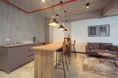 a kitchen and living room with a table and a couch at Enchanted Elegance in Laureles in Medellín