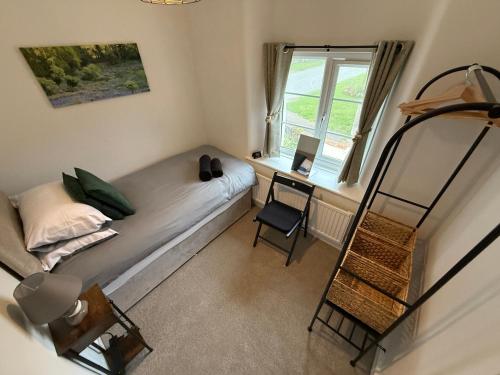 une petite chambre avec un lit et un bureau dans l'établissement 3 Bed East Devon close to Otter Valley National Nature Reserve and sea, à East Budleigh