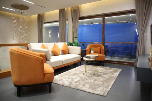 a living room with a couch and two chairs at Hills and Heart Luxury Villa By LexStays in Coonoor