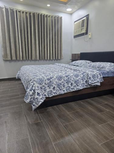 a bedroom with a bed with a blue comforter at المرقاب للشقق المخدومه 1 in Al Jubail