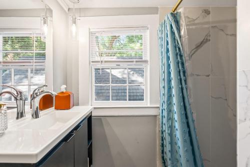 ein Badezimmer mit Waschbecken und Dusche in der Unterkunft Spacious 4BD - Sleeps 10 - Movie Night & BBQ in Durham