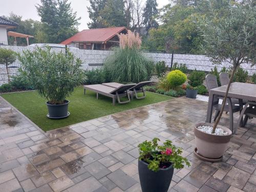 a patio with a table and chairs and plants at Három Testvér Apartman in Siófok