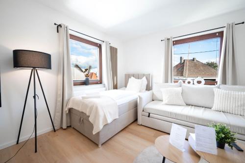 a white living room with a couch and a window at Malu Rooms - Attraktive Lage, Balkon, SmartTv, 24h Checkin, Waschmaschine, in Ludwigsburg