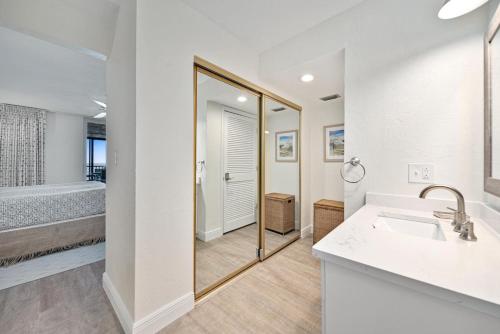 ein Badezimmer mit Badewanne, Waschbecken und Spiegel in der Unterkunft Atrium #304 in Ybel