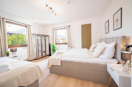 a white bedroom with two beds and a window at Malu Rooms - Attraktive Lage, Balkon, SmartTv, 24h Checkin, Waschmaschine, in Ludwigsburg