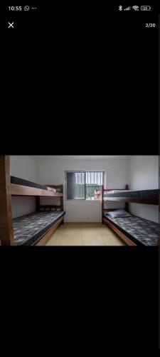 a room with two bunk beds and a window at Praiamongagua in Mongaguá