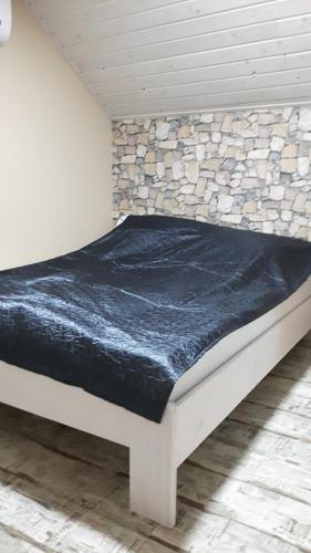 Manó Apartman في إغير: سرير في غرفة بجدار حجري