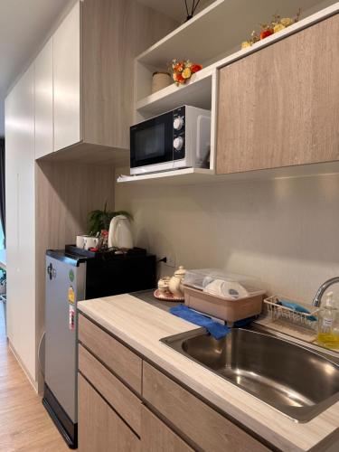a small kitchen with a sink and a refrigerator at AVALYN Room Plus II - East Ville in Ban Hua Khao Sammuk