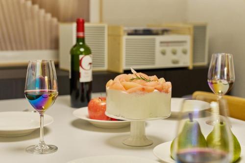 a table with a cake and two glasses of wine at 트리하우스 서울 롯데월드 Kspo 동대문 성수동 in Seoul