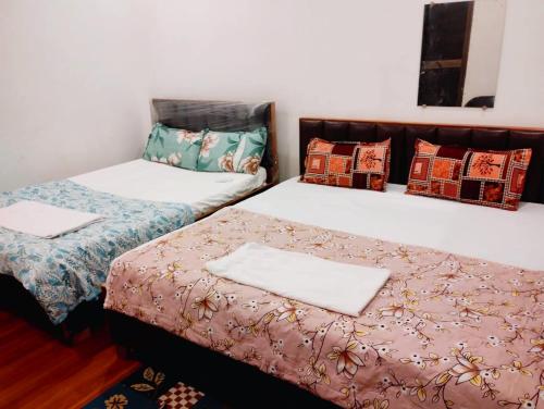 two beds sitting next to each other in a room at Hotel AV Palace Near Ram Mandir Ayodhya in Ayodhya