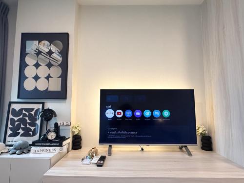 a flat screen tv sitting on top of a table at AVALYN Room Plus II - East Ville in Ban Hua Khao Sammuk