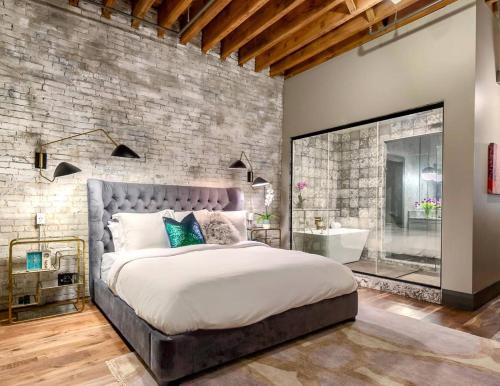 Un dormitorio con una cama grande y una pared de ladrillo. en The Producers Loft, en Nashville