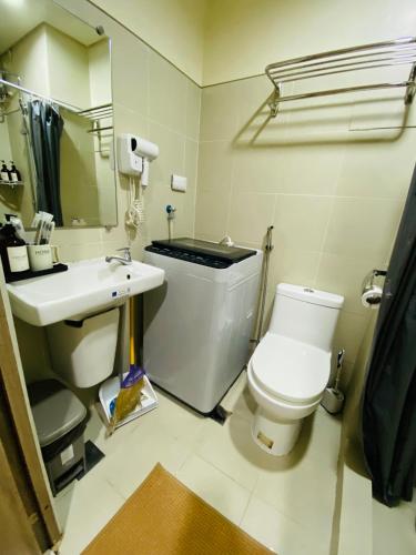 a bathroom with a white toilet and a sink at S Residences Condo PoolView Balcony in SM MOA near NAIA in Manila