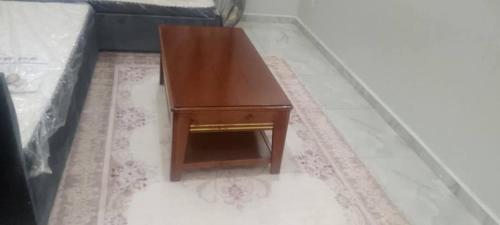 a wooden coffee table sitting on the floor next to a couch at Apartment f2, 58 m situé a kaktakit Boumerdes in Boumerdes