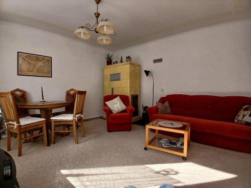 a living room with a red couch and a table at Ferienhaus-Juliana in Stolberg i. Harz