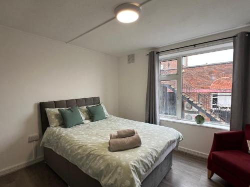 a bedroom with a large bed and a window at Bridge Hotel Apartments in Frodingham