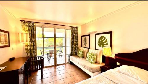 Una habitación de hotel con una cama, un escritorio y un balcón. en Appartement Ti-Paradis - RDC, en Sainte-Luce