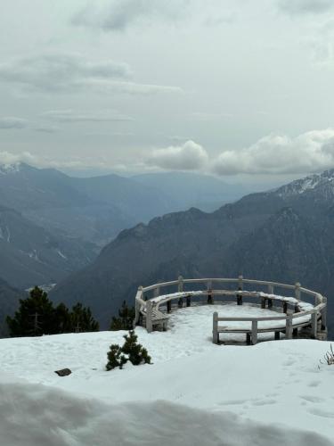 a bench sitting on top of a snow covered mountain at Buni i Bajraktarit in Bogë