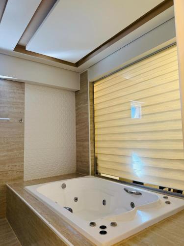 a large bath tub in a bathroom with a window at Nacional Palace Hotel in Corumbá