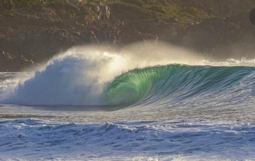 a large wave in the ocean with a green at Casa del Sol in Cobquecura
