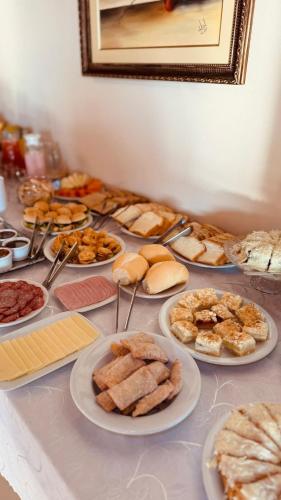 サン・ボニファーシオにあるPousada Dona Teresinha - São Bonifácio/SCの皿に盛られた様々なペストリーを楽しめるテーブル