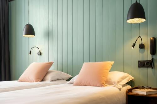 アニエール・シュル・セーヌにあるHotel SUBのランプが2つと緑の壁がある寝室にベッドが2つある