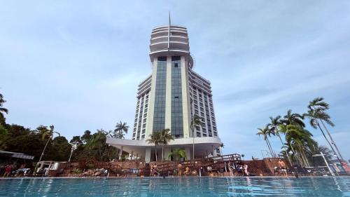 Un edificio alto con una piscina enfrente. en Tropical Executive Flat Suites 507 view, en Manaus