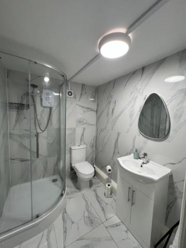 a bathroom with a shower toilet and a sink at Bridge Hotel Apartments in Frodingham