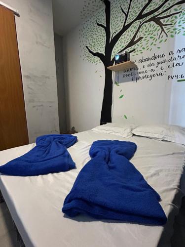 two blue towels sitting on top of a bed at Tree Suíte Comfort in Garanhuns