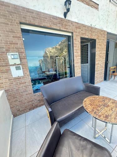 a living room with a couch and a table at "Seaside Studio with Stunning Views in Belyounech in Belyounech 