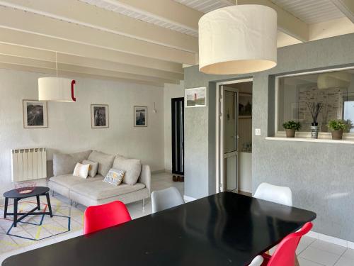 ein Wohnzimmer mit einem schwarzen Tisch und roten Stühlen in der Unterkunft L'Abri du Rouget, 5 minutes à pied de la plage du Trez-hir, vacances en famille in Plougonvelin