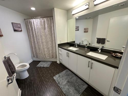 Un baño con inodoro, lavabo y espejo. en 2BR w parking located DTLA!!, en Los Ángeles