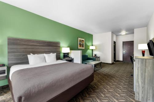 a hotel room with a bed and a flat screen tv at Quality Inn & Suites Salt Lake City Airport West in Salt Lake City