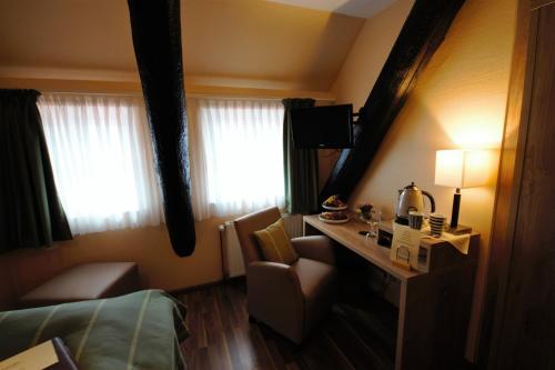 a hotel room with a bed and a desk and window at Hotel Marktkieker in Großburgwedel