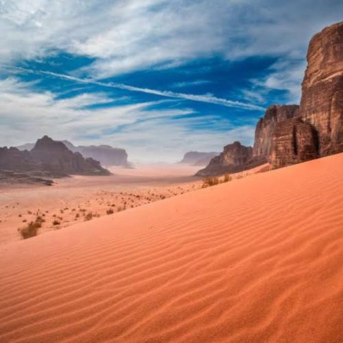 Un desierto con montañas al fondo y un cielo en Suleman Camp, en Wadi Rum