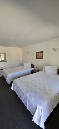 two beds in a hotel room with white sheets at Country Inn Marion in Marion