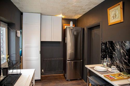 a kitchen with a stainless steel refrigerator in a room at 2BR Home in Manchester near Etihad Stadium with Parking in Manchester