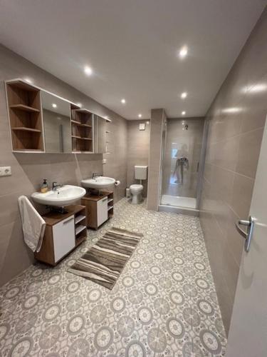 une salle de bain avec deux lavabos et une douche dans l'établissement Miami Monteur Apartment, à Rodenbach