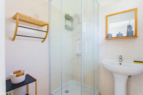 プティ・ブールにあるGrazuëlla - Garden & Terraceのガラスのシャワーと洗面台を備えたバスルーム