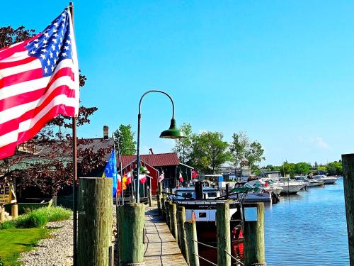 an american flag flying next to a marina with boats at Cool City Motel in Two Rivers