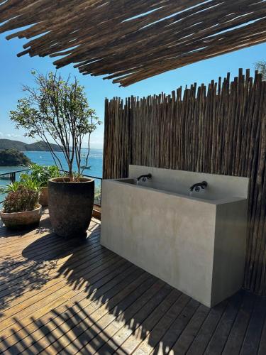 a bathroom with a tub and a wooden fence at Abracadabra Boutique Hotel in Búzios