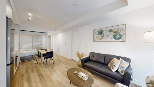 a living room with a couch and a table at Cozy 2 Bdrm 2 Bath Entire Suite - Centre Hamilton in Hamilton