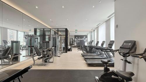 a gym with a row of treadms and machines at Cozy 2 Bdrm 2 Bath Entire Suite - Centre Hamilton in Hamilton